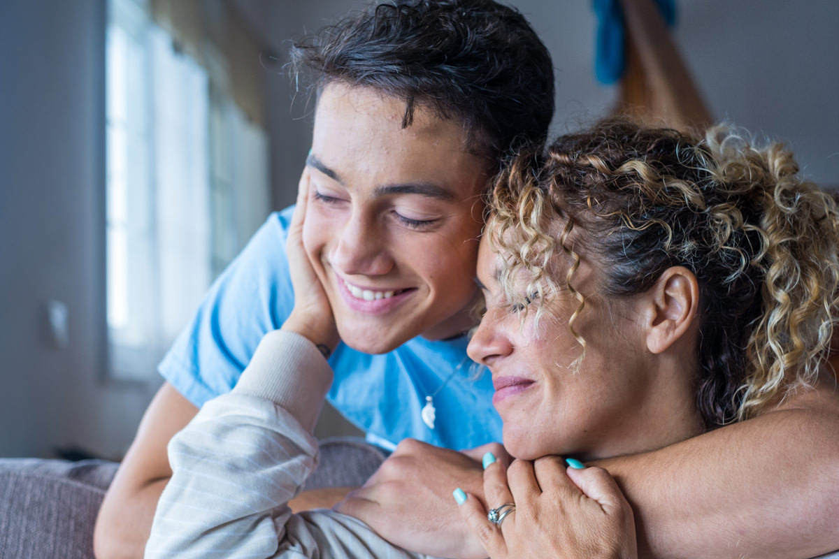 A mom with her teen son smiling